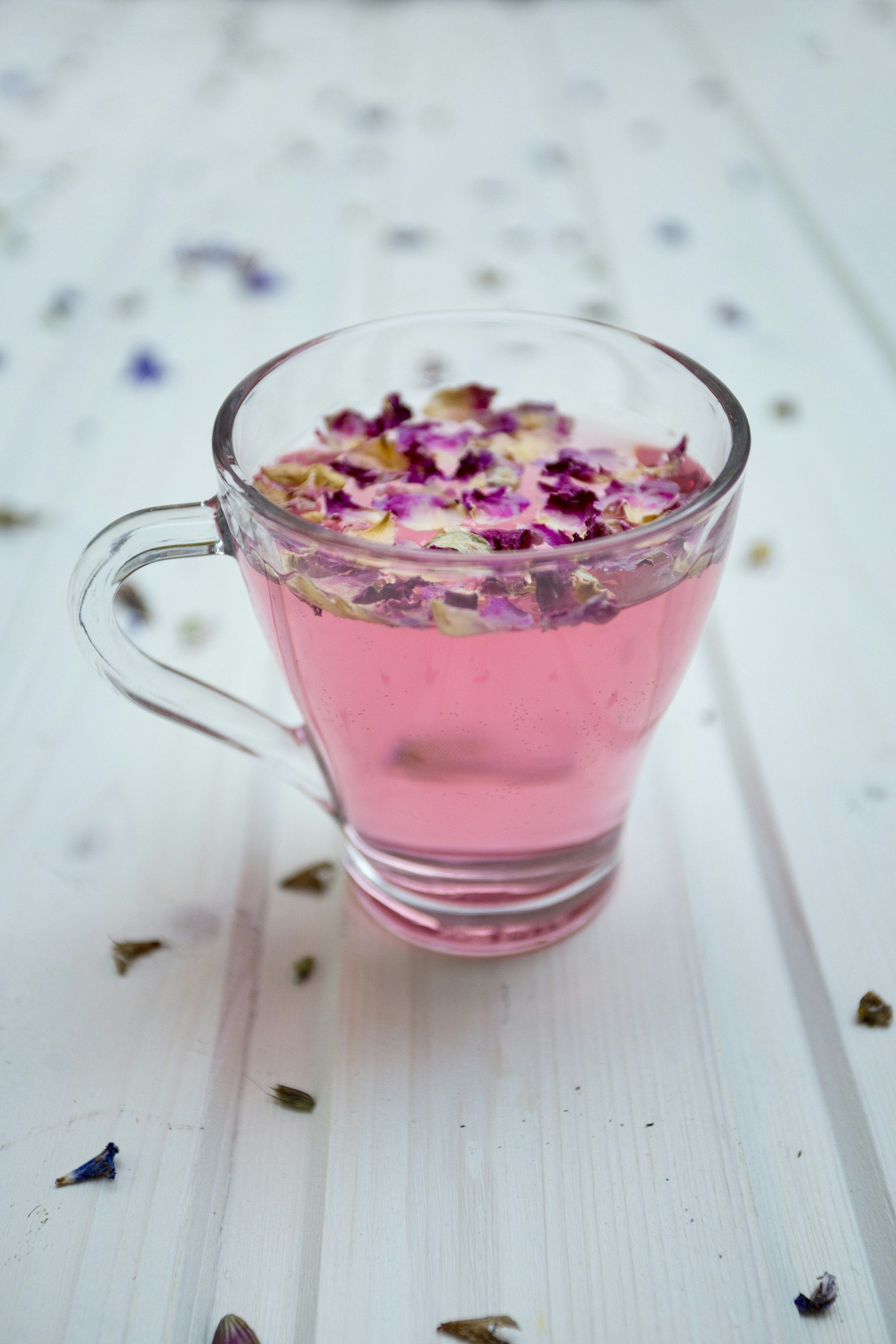 Xícara de vidro com pétalas florais e infusão